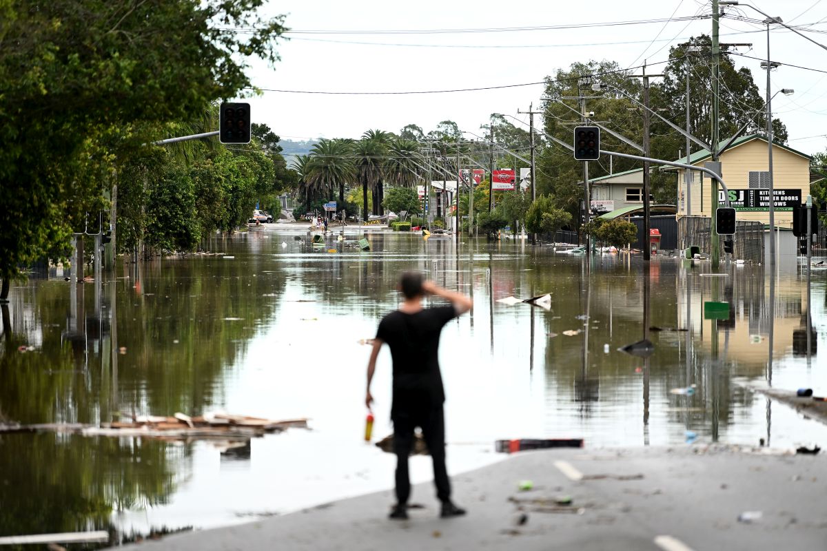 A man watches as a street floods.