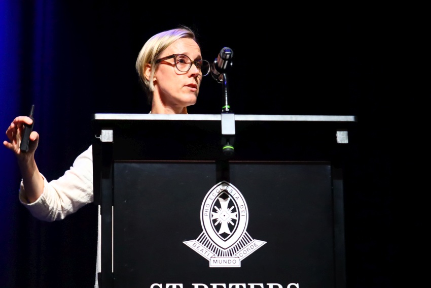 Photograph of a blond woman at a podium during a speech