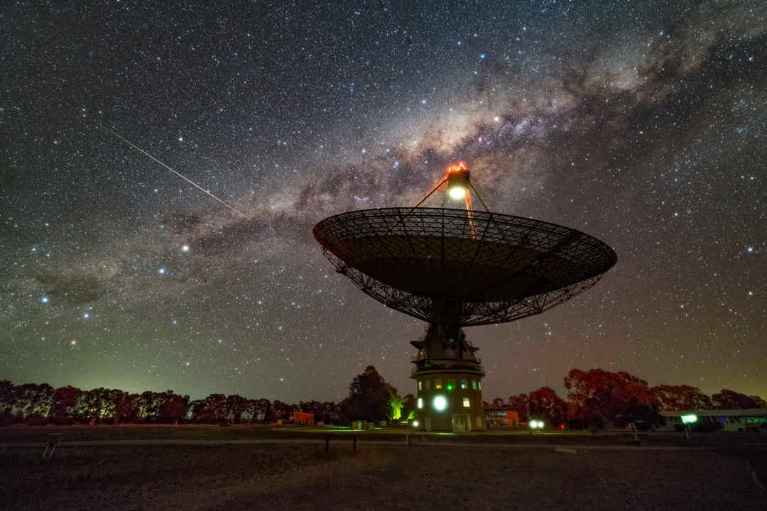 radio telescope dish under night sky stars milky way