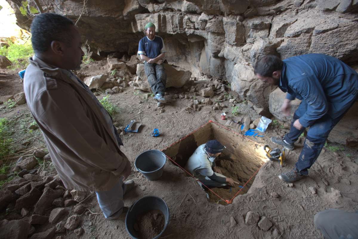 People excavating a site inside a cave