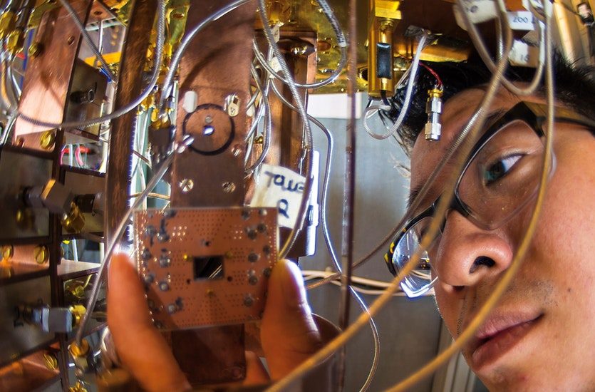 The cutting-edge science of quantum computing requires nanoscale precision mixed with the tinkering spirit of home electronics. Researcher jerry chow is here shown fitting a circuitboard in the ibm quantum research lab.