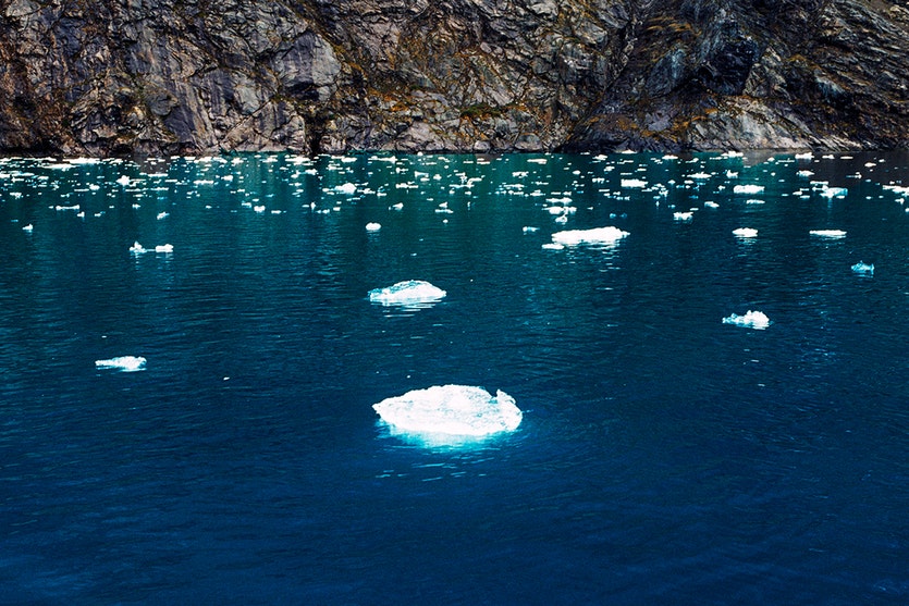 Broken pieces of glacier ice floating in the waters of greenland’s fjord of eternity.