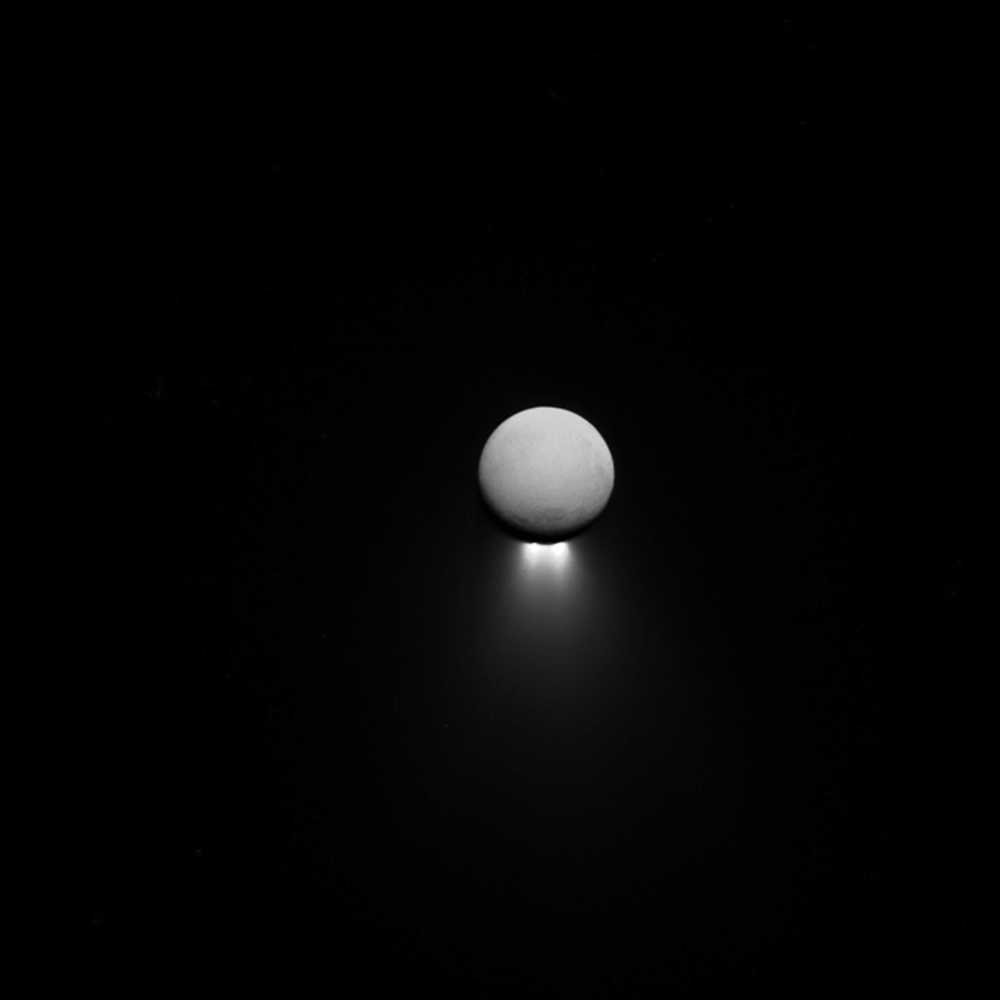 Saturn’s moon enceladus with the sun behind it.