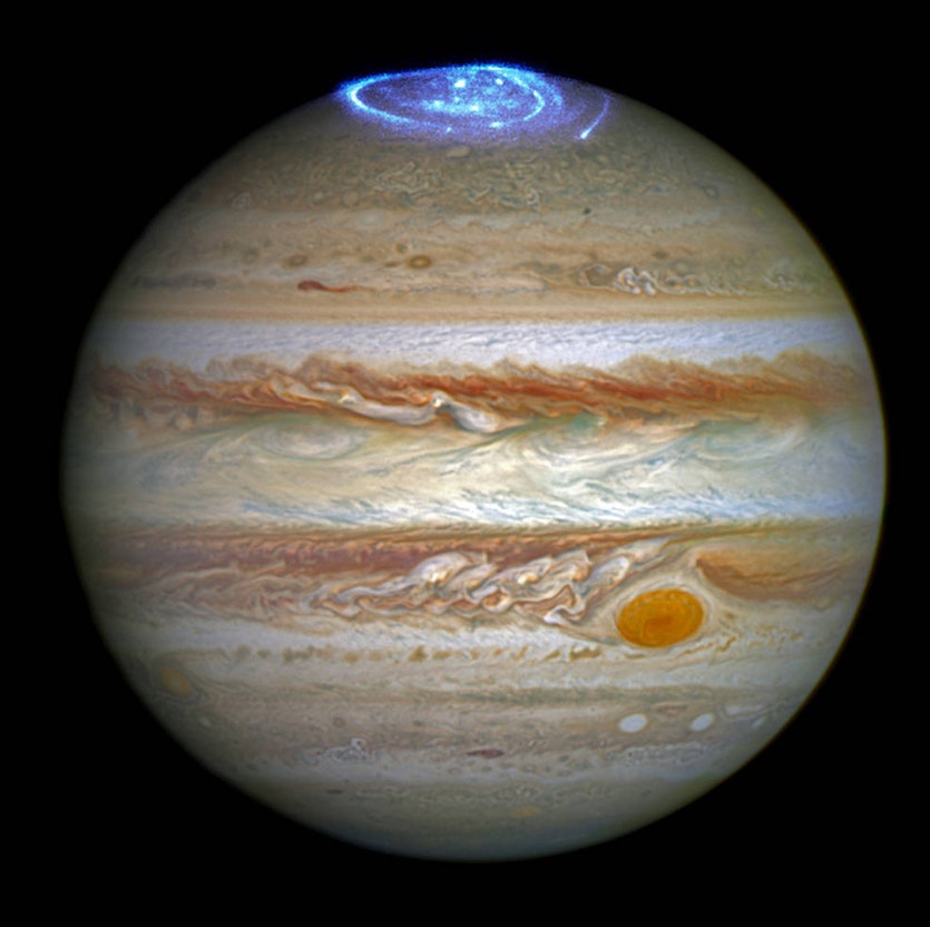 A composite image from the hubble space telescope showing jupiter in visible light and its aurora in ultraviolet.