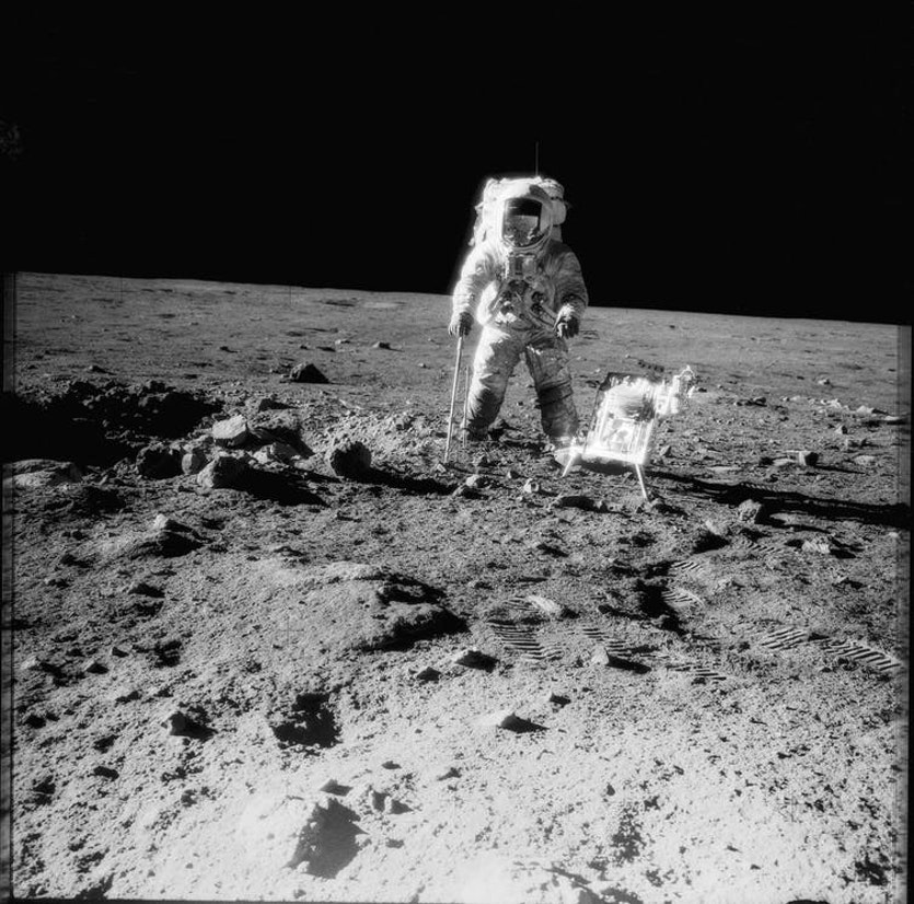 Apollo 12 crewman with tools and carrier of apollo lunar hand tools on the moon, november 1969.