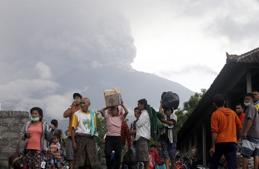 People evacuating in karangasem, indonesia, sunday, nov. 26, 2017 with mount agung in the background.