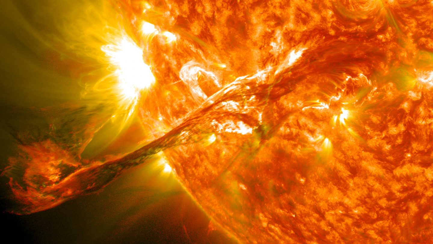 A massive filament of plasma bursts forth from the Sun.