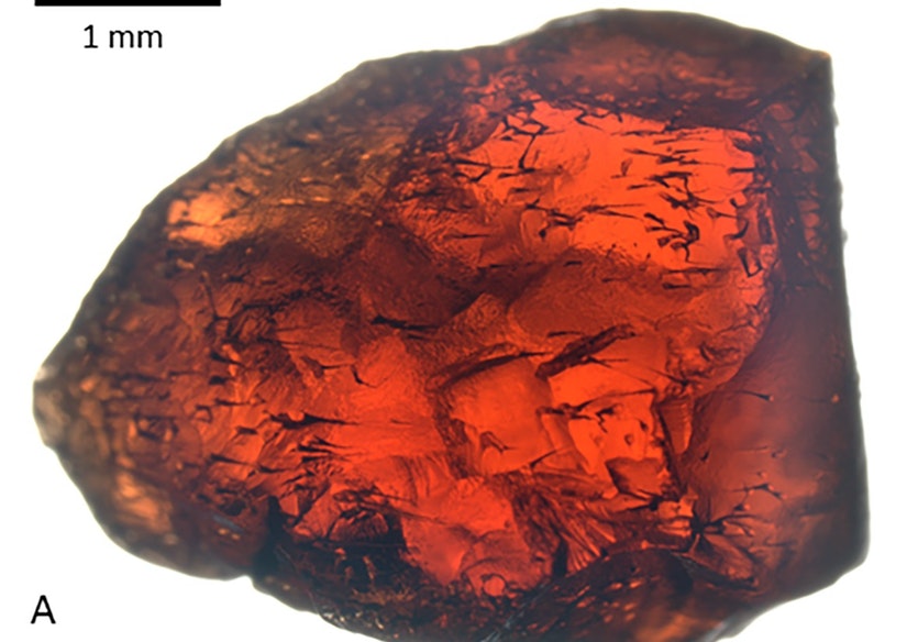 A garnet, with the tubular defects that decrease its value on the gem market.