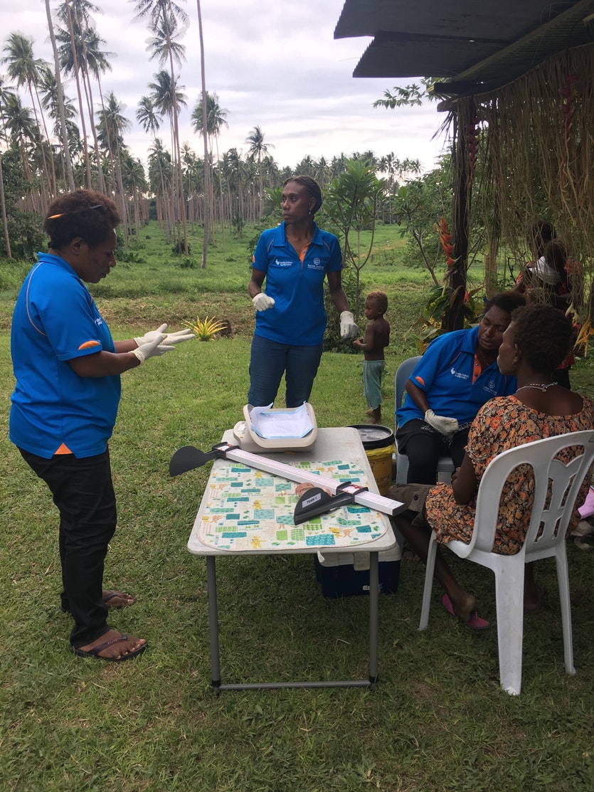 Members of the burnet team get ready to take a baby's vital statistics in a village near tovarur plantation in east new britain.