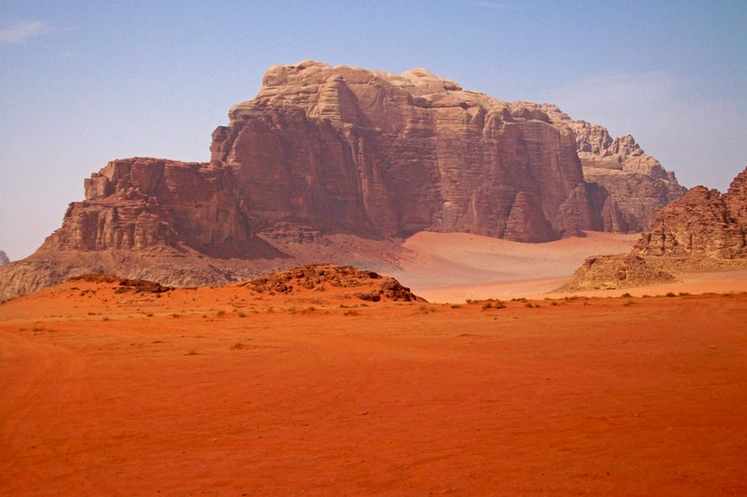 Wadi rum is a sand-filled valley cut into sandstone and granite in jordan.