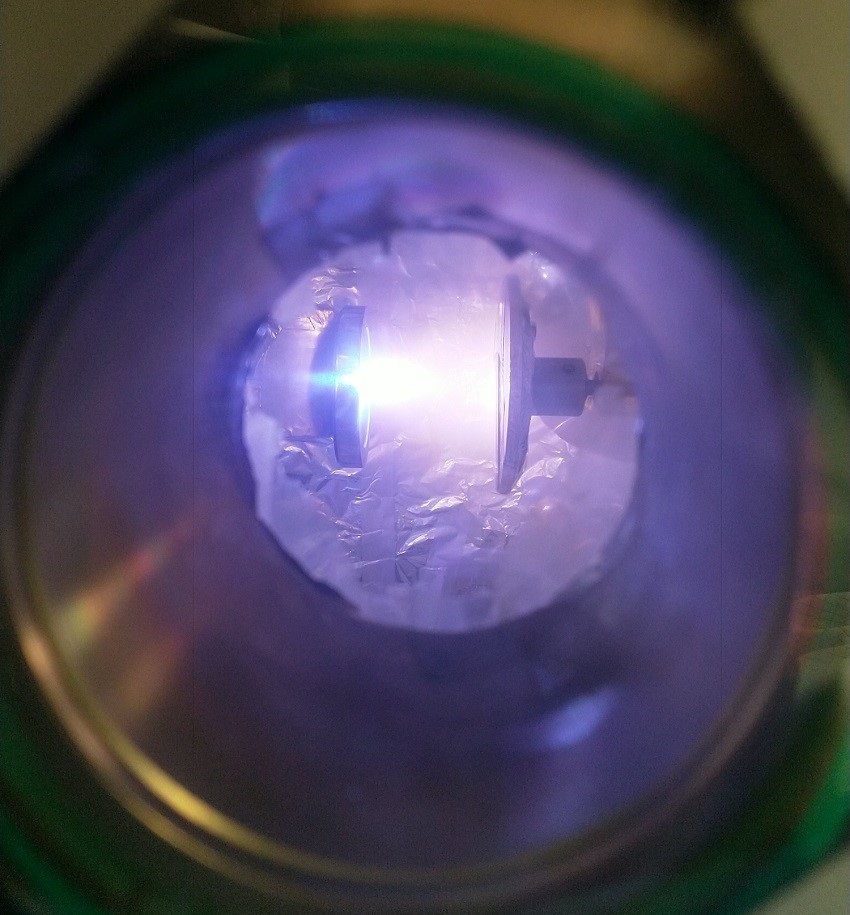 which injects outwards at high speed. The plasma cools extremely quickly to form a film of glassy (amorphous) aluminium oxide upon colliding with the substrate on the right side of the image.