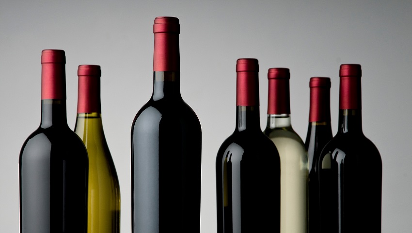 Generic alcohol and wine bottles against grey background