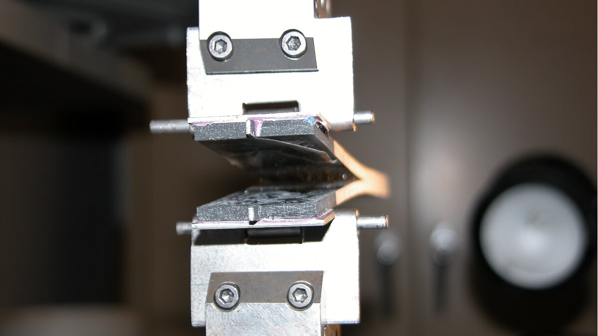 A traditional method of testing for fractures, where hinges are bonded onto each side of the material.