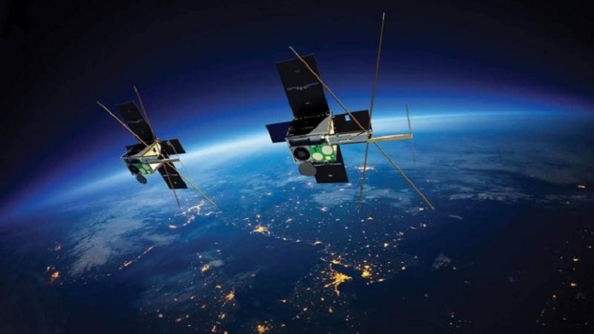 Two cubesat satellites flying past earth