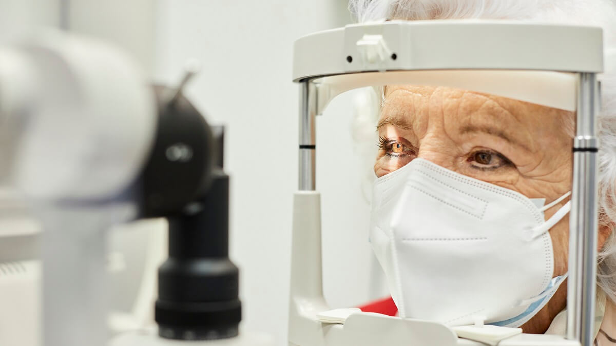 Photo of a woman wearing a mask and having an eye exam