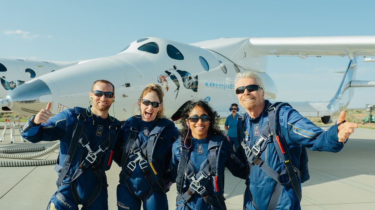 Four people in blue suits. Two men and two women. They all wear sunglasses and straps on their body