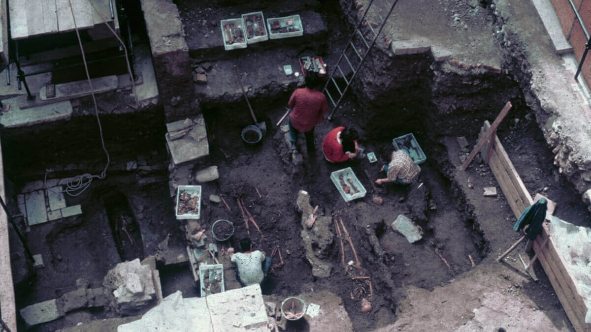 Photo of an excavation of a grave in Rome in 1992, with people oncvoering skeletons in graves