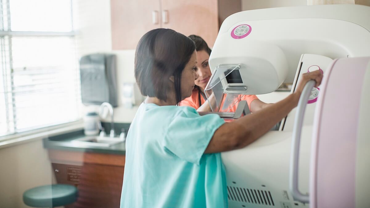 Woman receiving a mammogram from a nurse
