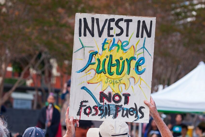 A protester holds a placard that reads: "invest in the future, not fossil fuels"