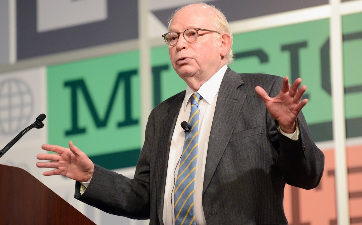 Man in suit with glasses (Steven Weinberg) speaking on a stage