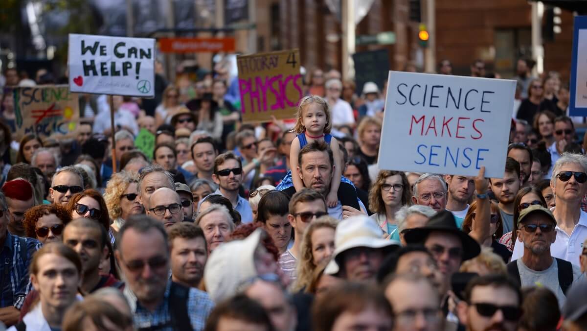 A crowd with signs supporting science