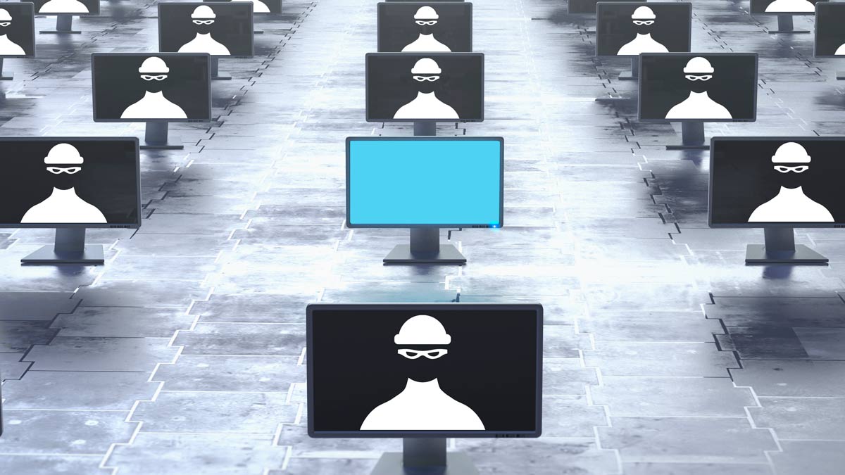 Rows of computer screens with a silhouette of a hacker on them.