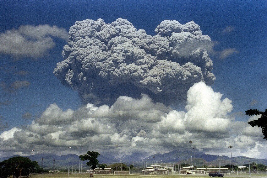 A volcano erupting a huge cloud of ash into the sky.