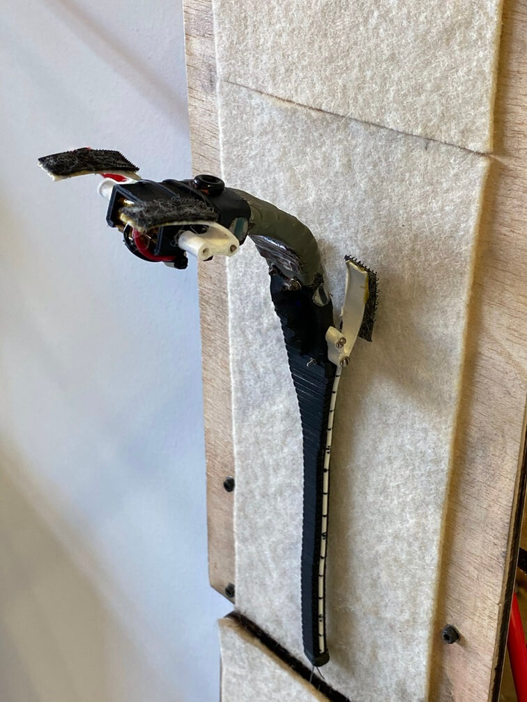 A black robot gecko on a velcro wall