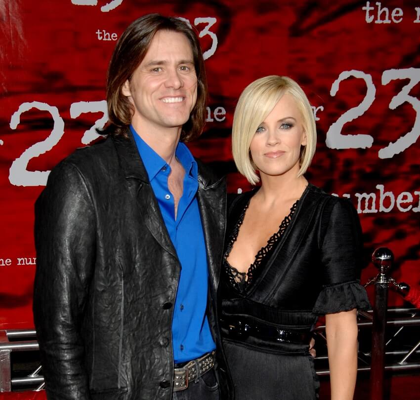 Jim carrey and jenny mccarthy stand in front of a the number 23 poster