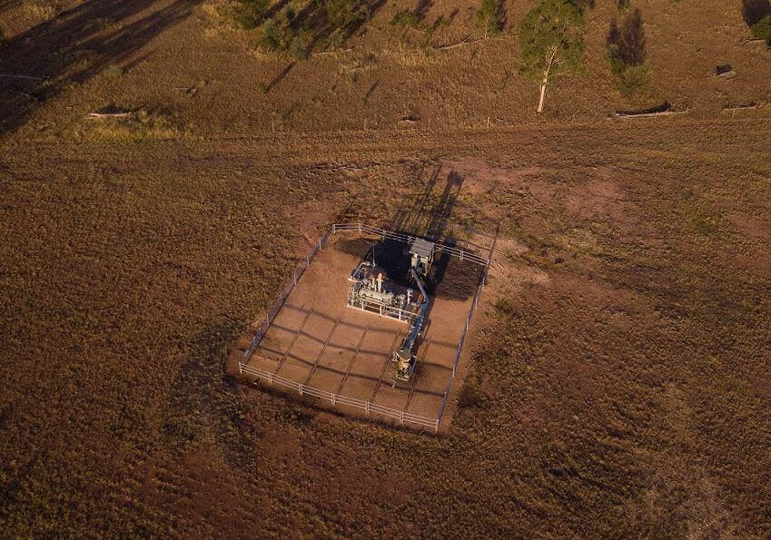 Aerial shot of coal seam gas well on arid red country.