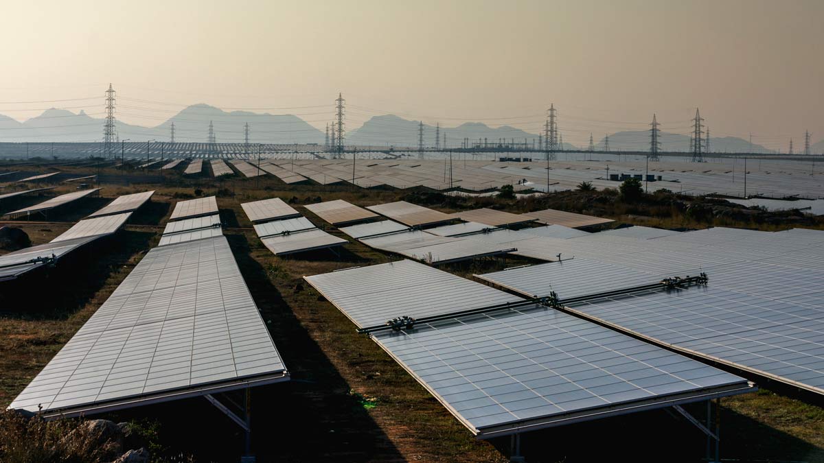 A field of solar panels with mountains in the background