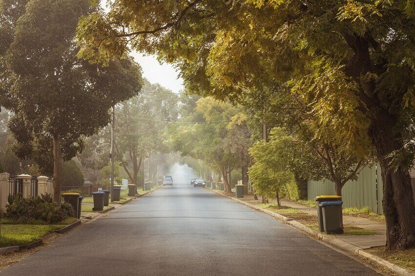 Foggy autumn morning in adelaide suburbs with rubbish recycling on kerb