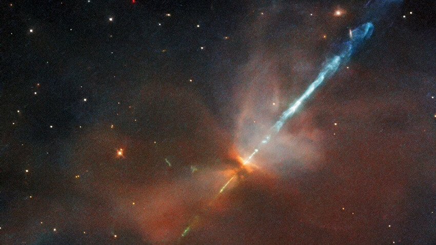 Two jets of blue light stream out from a dust cloud.
