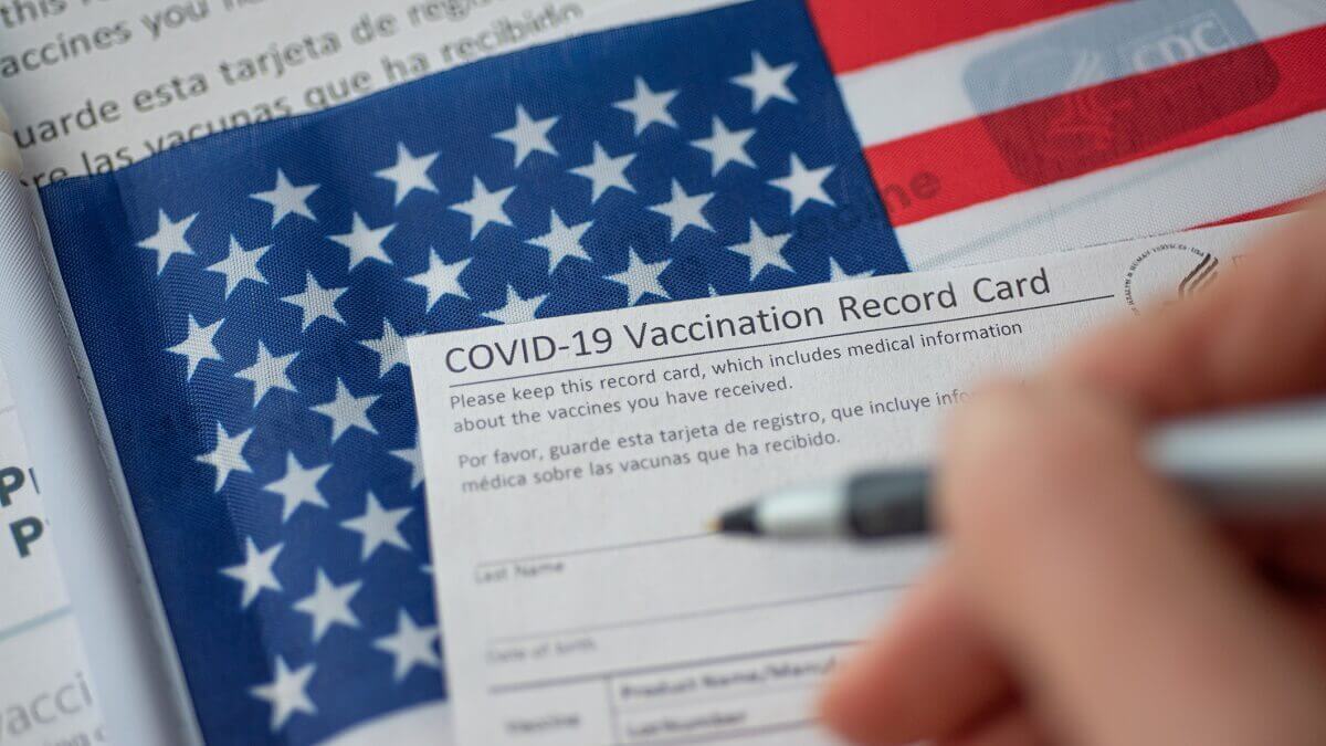 COVID vaccination form in front of an American flag