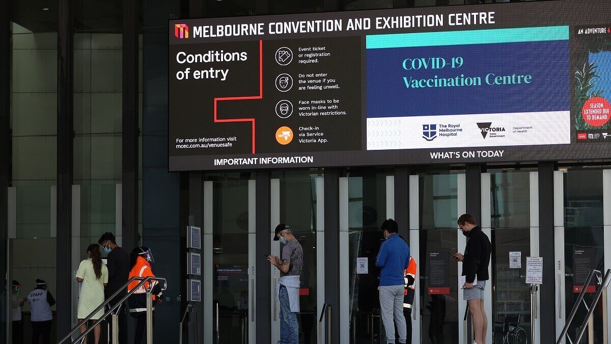 photo of people lining up outside vaccination hub at melbourne convention centre