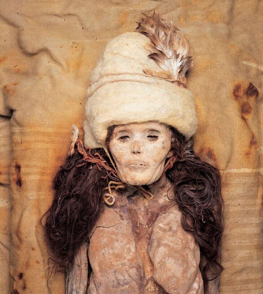 Above view of a mummified female corpse with a white fur hat