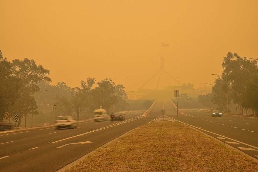 The australian parliament house is hardly visible behind a dense smog.