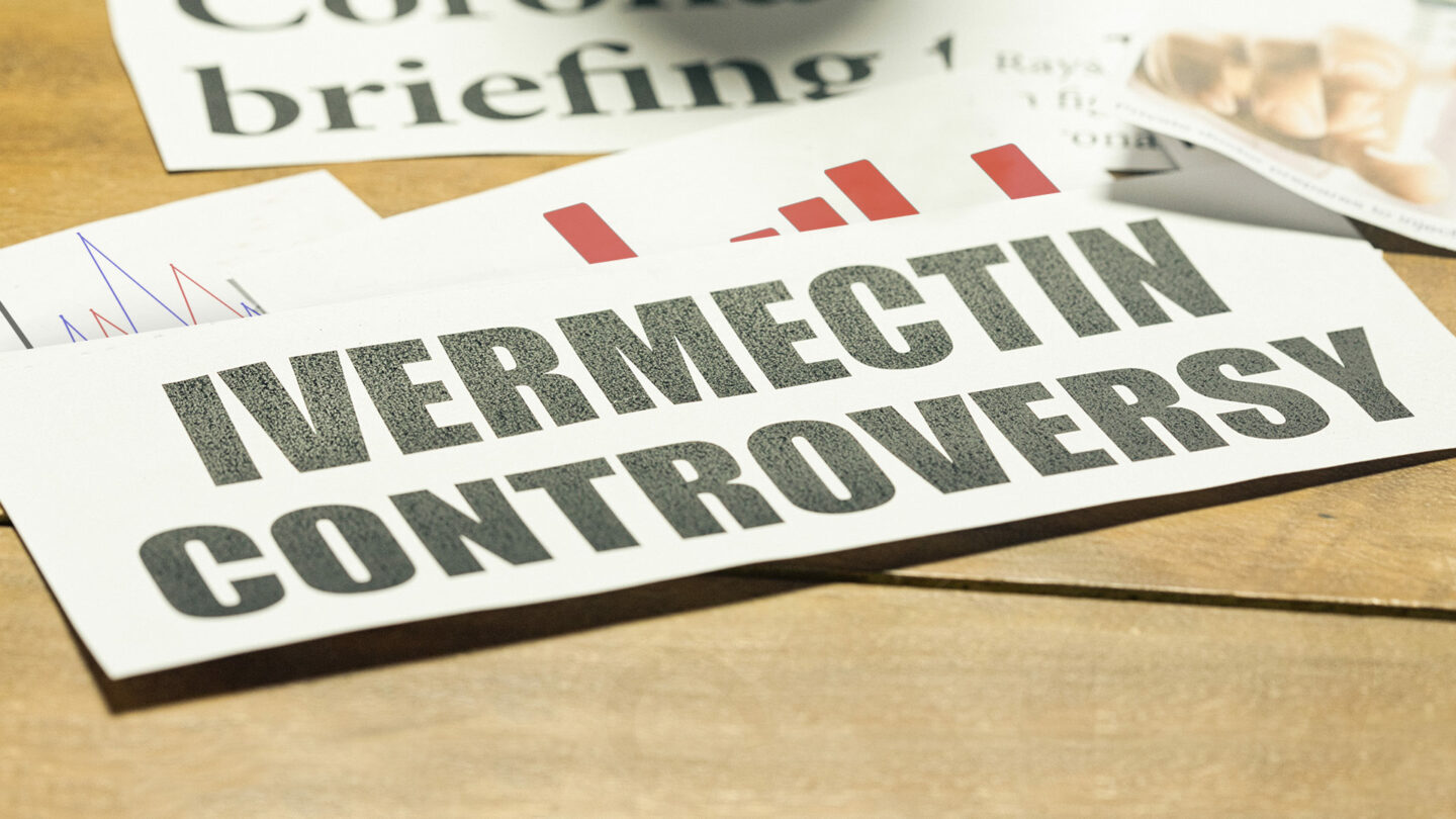 Newspaper headline about ivermectin controversy, with charts behind it