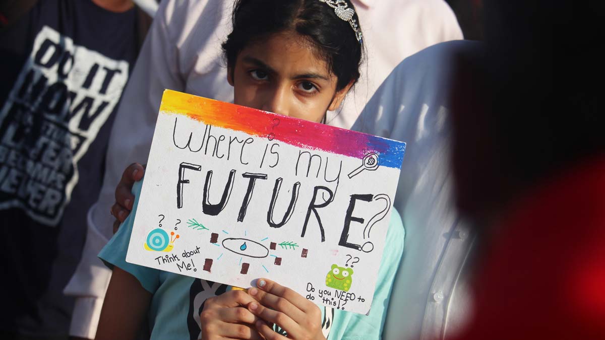 young girl holding sign that reads where is my future