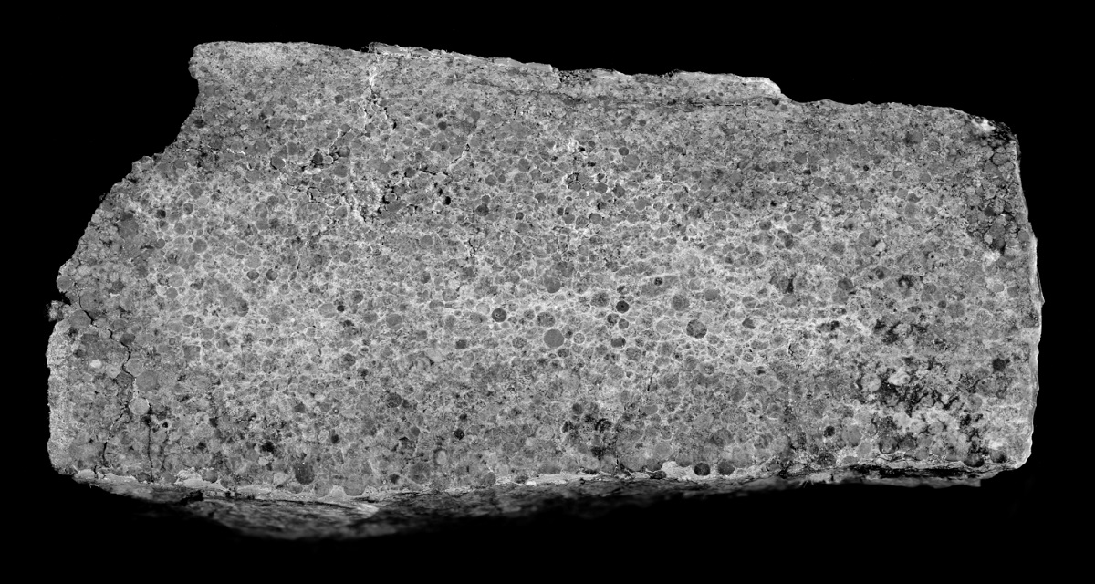Rock sample showing small spherical balls in it. Early asteroid bombardment.
