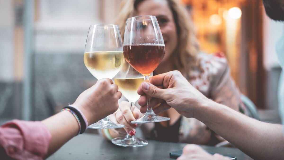 three people toasting glasses of wine