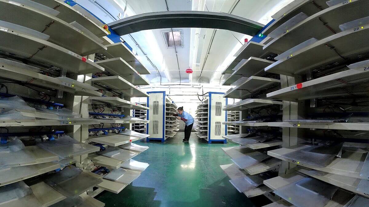 photo of a worker surrounded by shelves of lithium-ion batteries