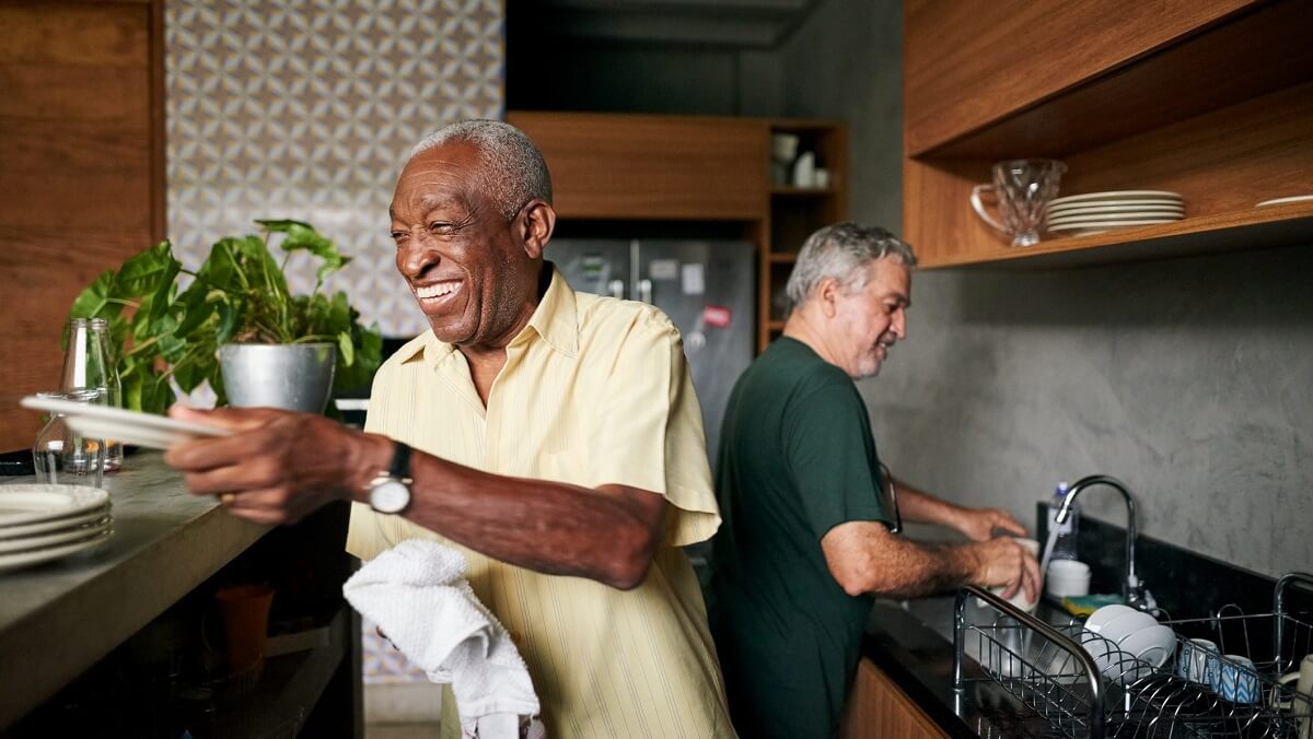 two elderly men doing the dishes together.