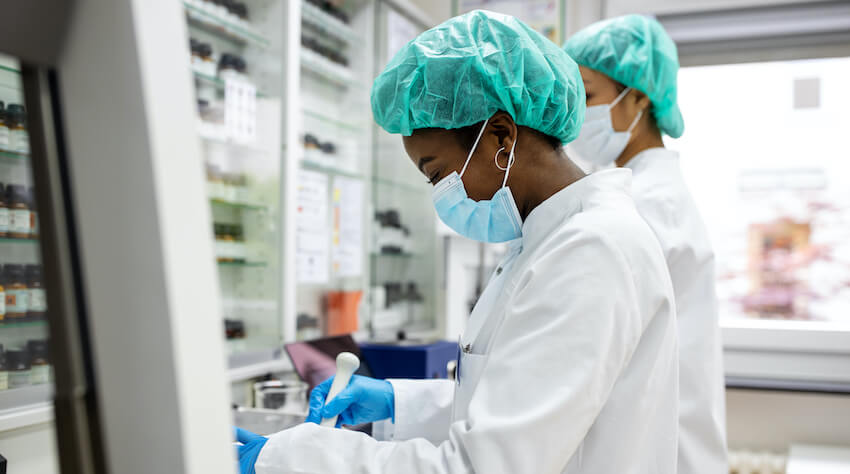 Black woman in white lab coat in laboratory
