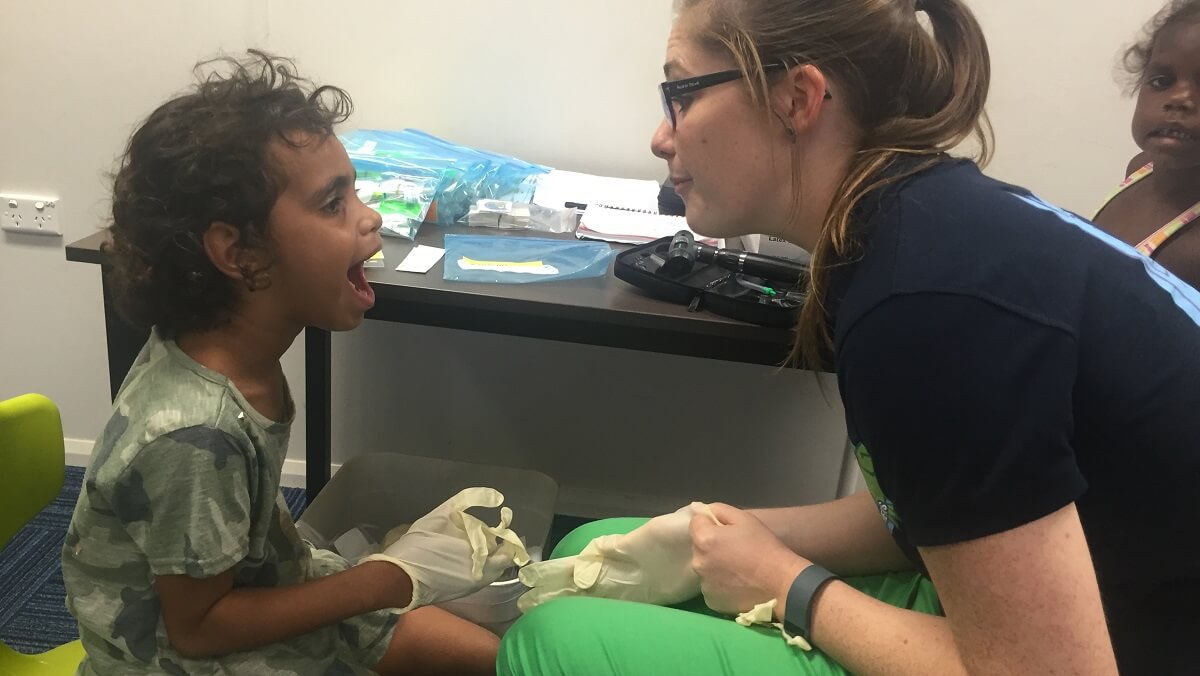 a doctor looking in a childs mouth