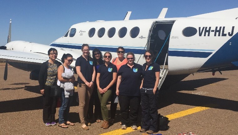 Doctors standing in front of a small plane