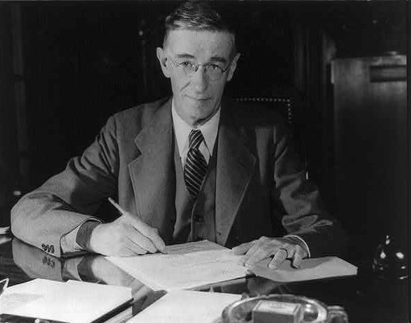 A black and white photo of a man with a pen in his hand, writing in a book