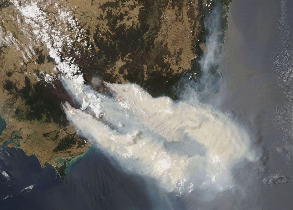 Satellite image of smoke pouring over ocean from continent