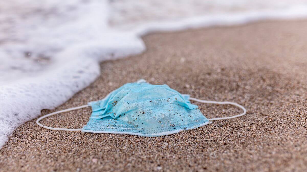surgical mask littered on a beach