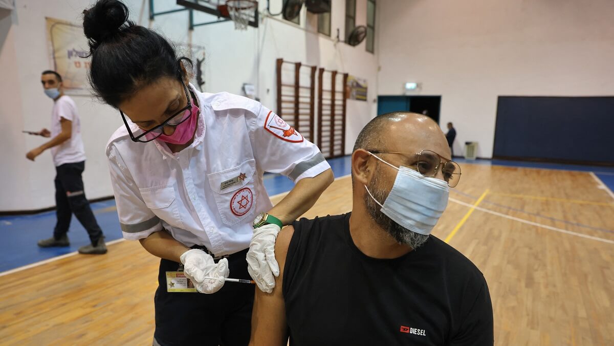 a woman administers an injection to a man